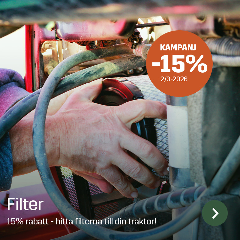 En hand monterar ett cylindriskt filter i traktorns motorutrymme, omgiven av slangar och metallrör. Sagros filter används vid service av traktorer för att säkerställa ren luft- eller bränsletillförsel i det dagliga lantbruksarbetet.